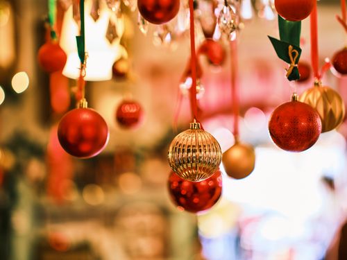 Free Close-up of beautiful gold and red Christmas ornaments hanging indoors with a warm festive glow. Stock Photo