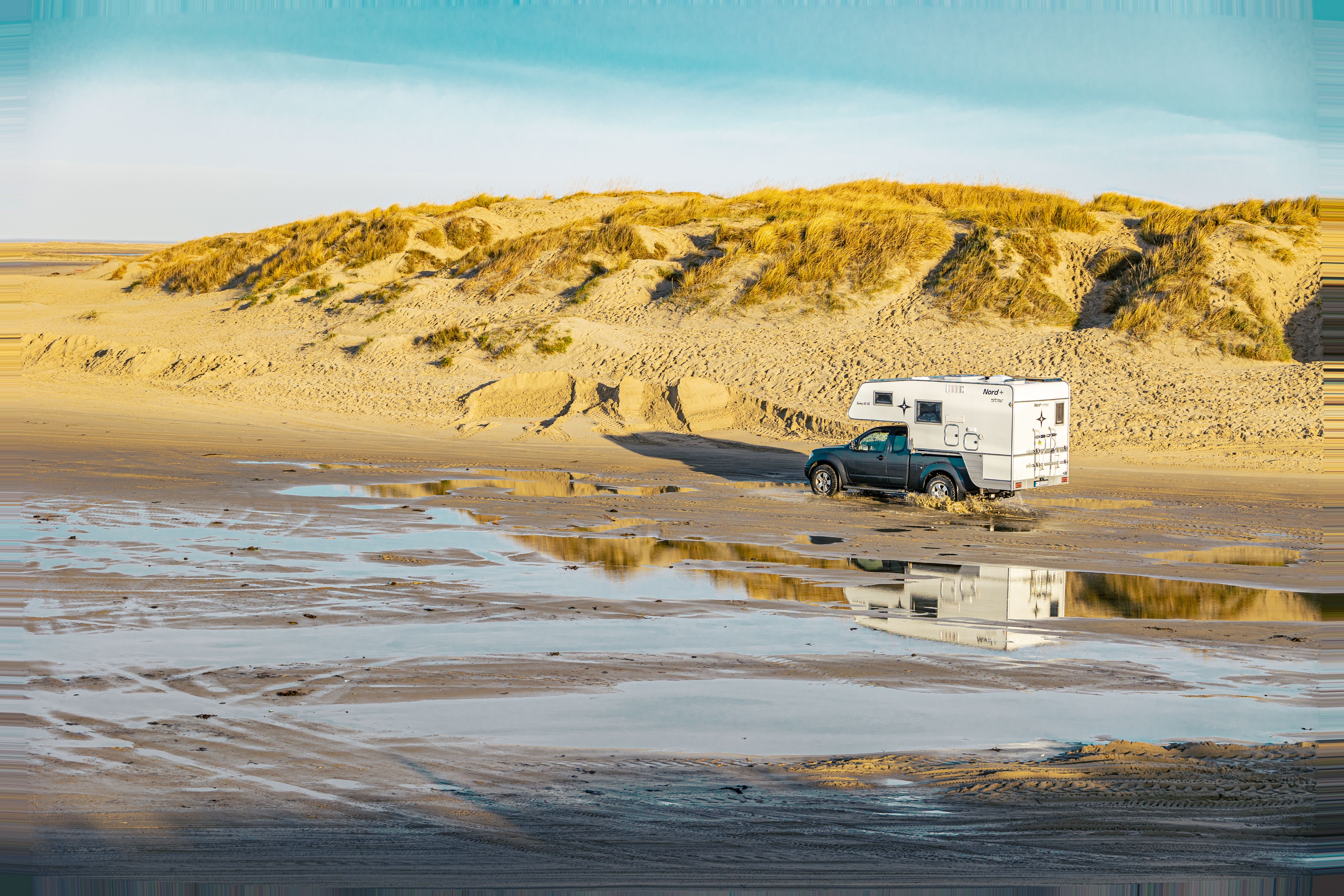 Campervan parked on a sandy beach in Rømø, Denmark.