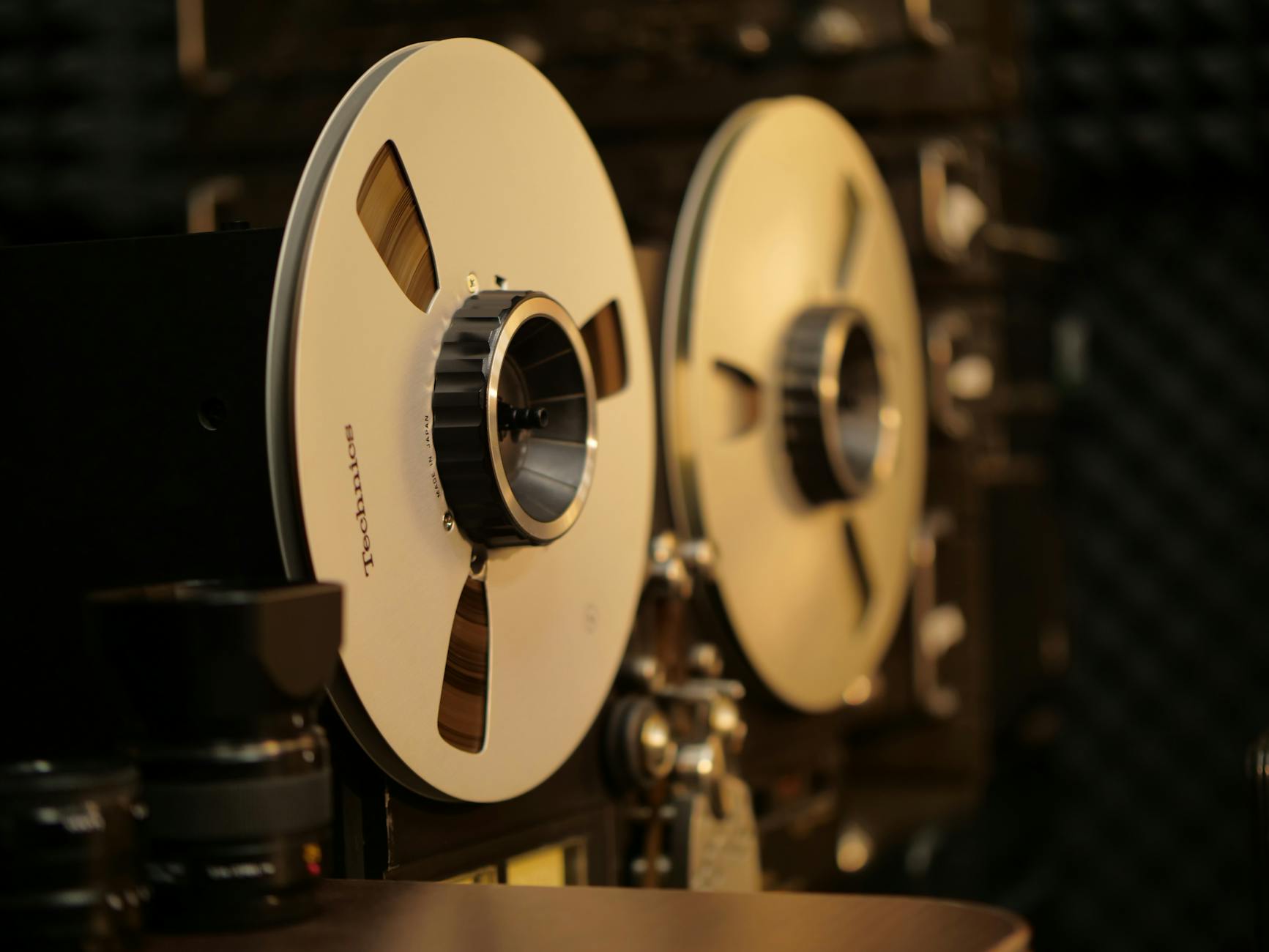 Close-up of a vintage reel-to-reel tape recorder in a professional audio recording studio.