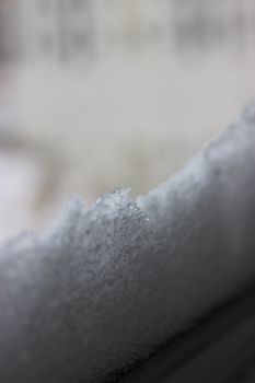 Macro shot of snow crystals highlighting their intricate structure and frosty texture.