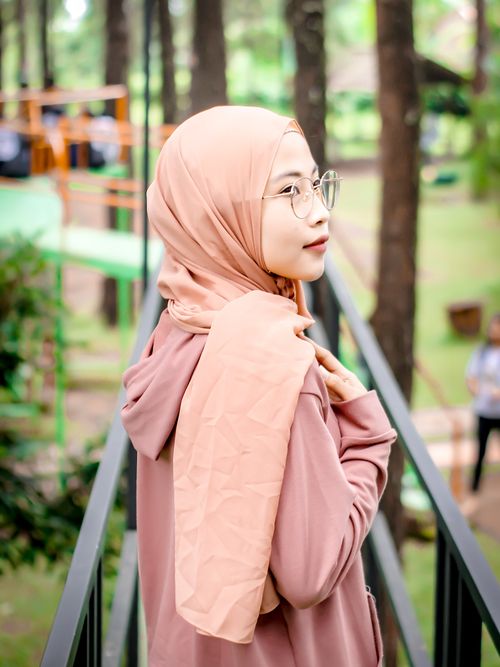 Free Young woman in a hijab outdoors, looking over her shoulder with a serene expression. Stock Photo