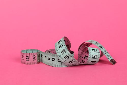 White Measuring Tape in Pink Surface 