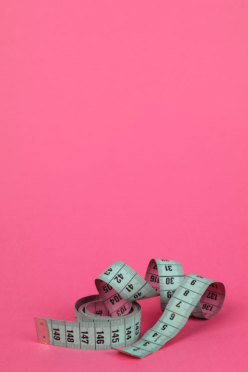 Measuring Tape in Pink Background 