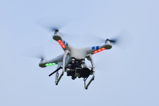 Close-up of a quadcopter drone flying with camera against a clear blue sky.