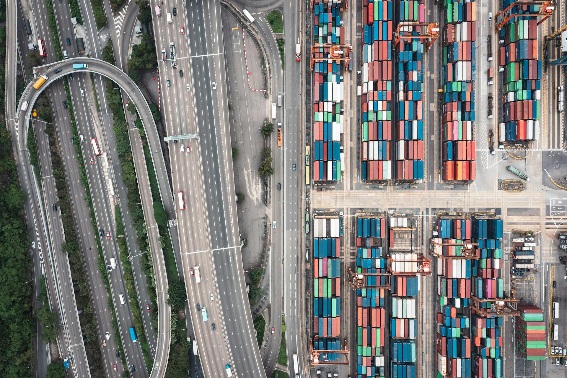 Aerial shot of Hong Kong's shipping containers and highway interchange showcasing urban logistics.