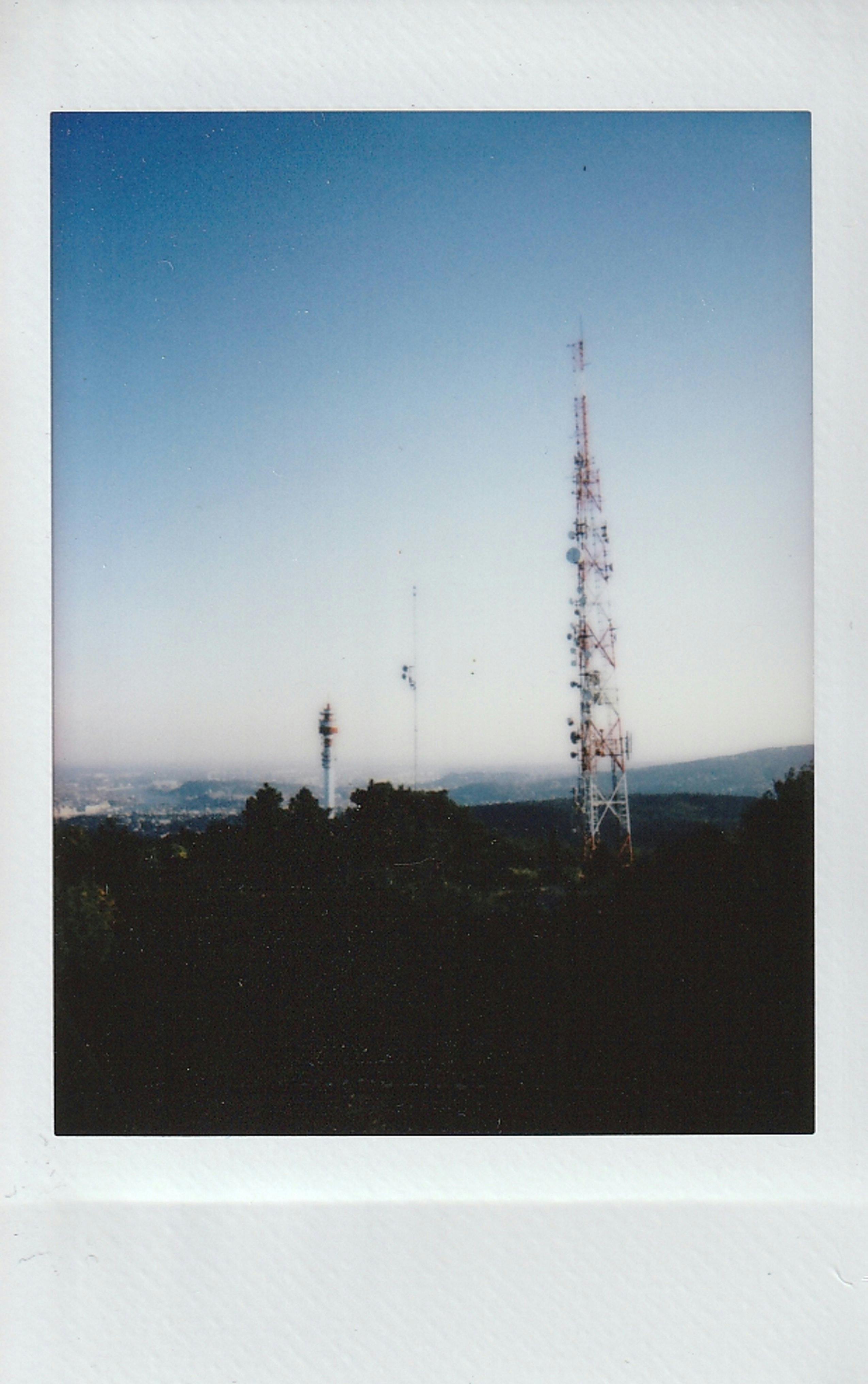 A distant view of TV towers against a serene landscape and clear sky.