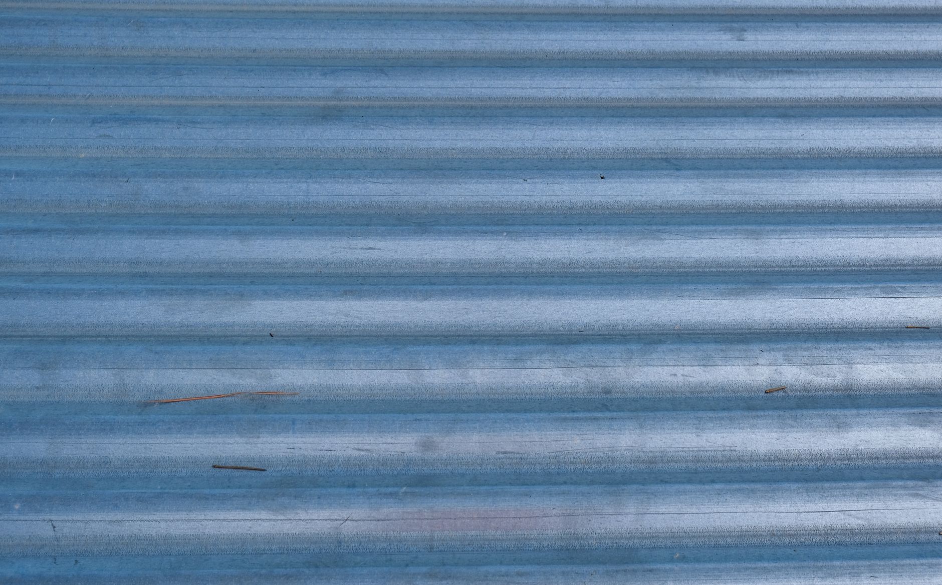 Close-up of corrugated blue metal surface with texture patterns, perfect for backgrounds.