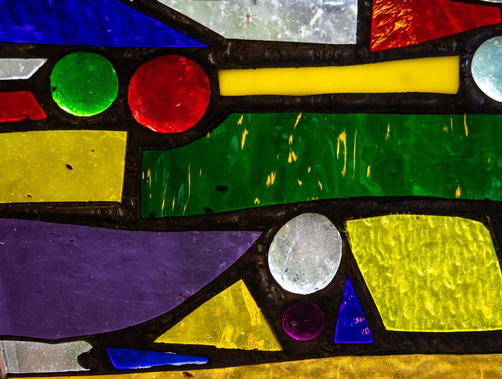 Free Vibrant stained glass window featuring colorful geometric shapes and patterns. Stock Photo