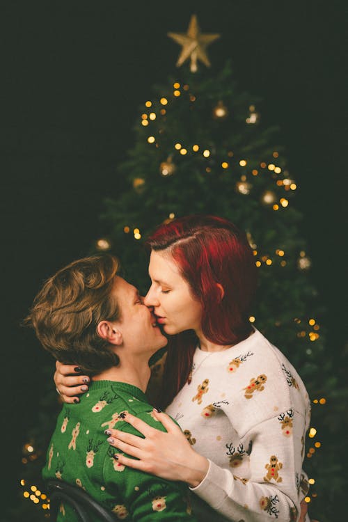 Couple Kissing in front of Christmas Tree