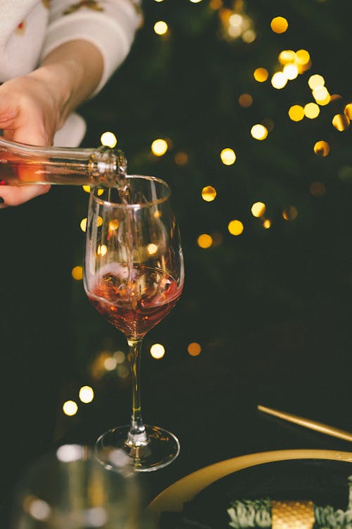 Person Pouring Wine Into a Wine Glass