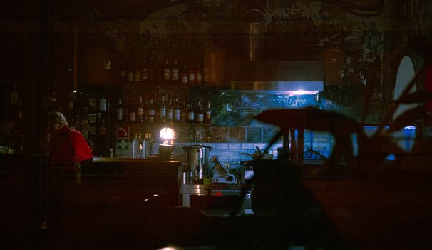 Dimly lit bar with bottles on shelves, creating a moody and intimate atmosphere.