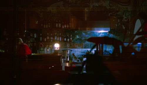 Free Dimly lit bar with bottles on shelves, creating a moody and intimate atmosphere. Stock Photo