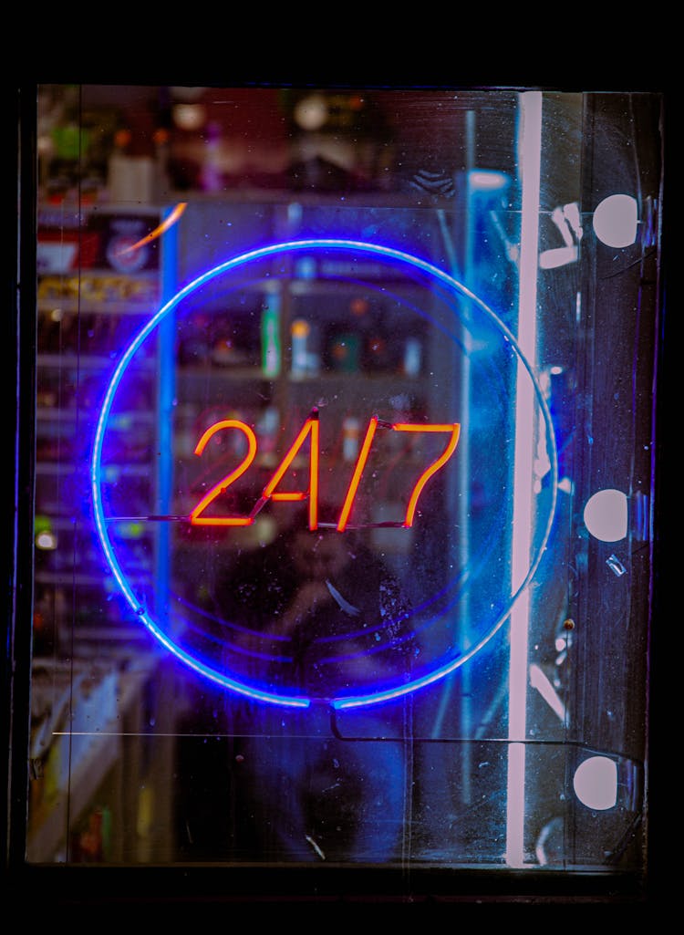 24/7 Sign On A Glass Door Of A Pharmacy