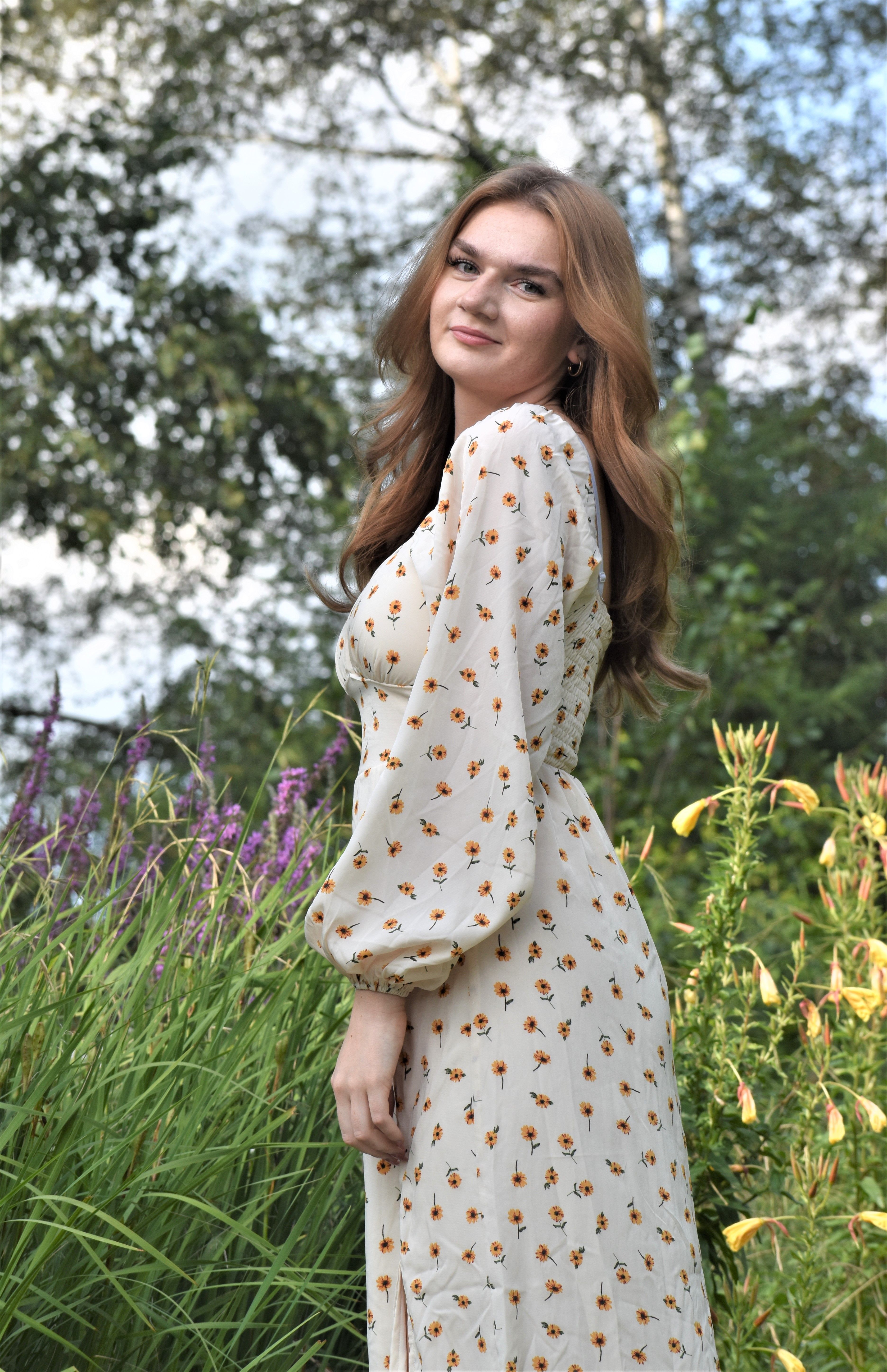 Woman in Floral Dress Standing Beside Tall Grass · Free Stock Photo