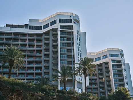 Contemporary hotel building exterior in Antalya, Turkey, featuring modern architecture and palm trees.