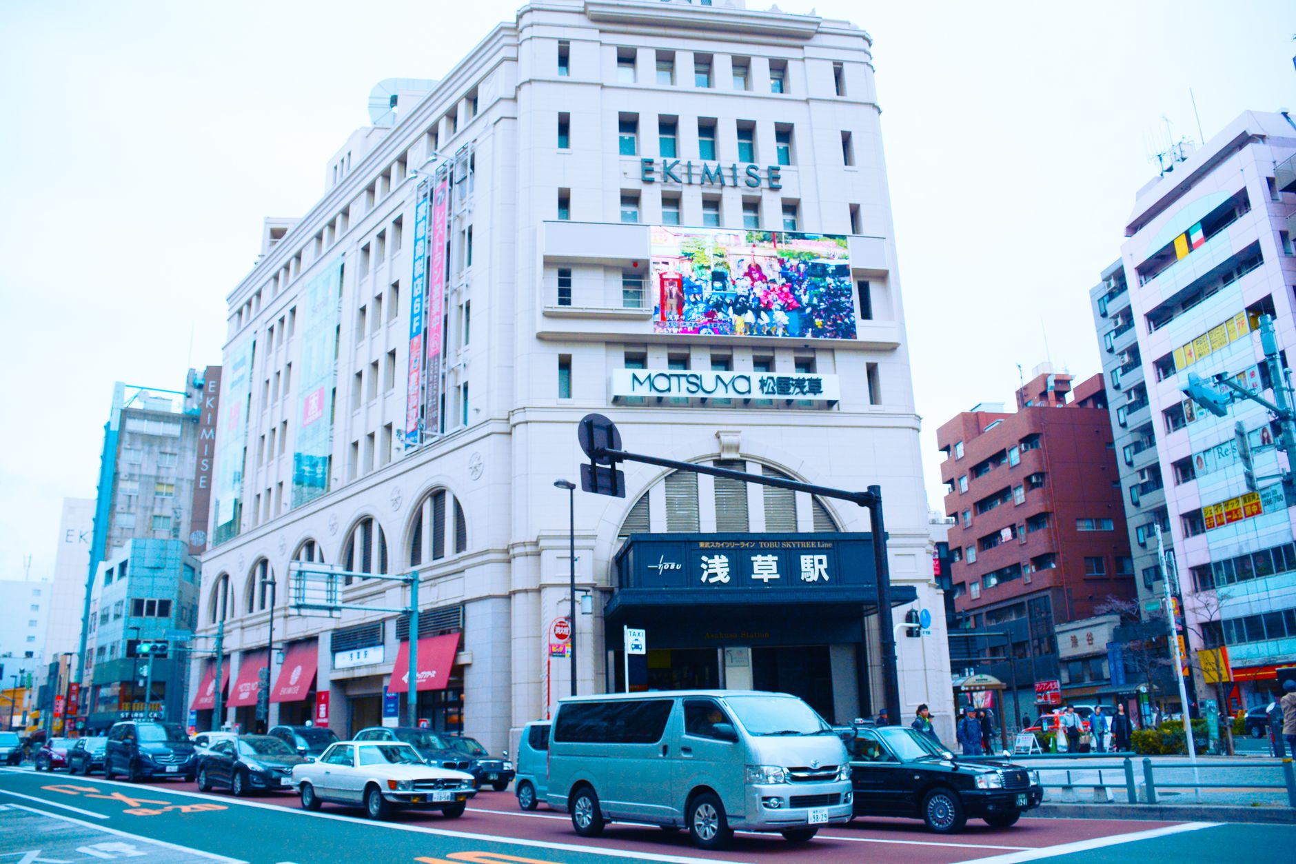 Street view of Asakusa in Taito, Tokyo featuring modern architecture and a busy urban setting.