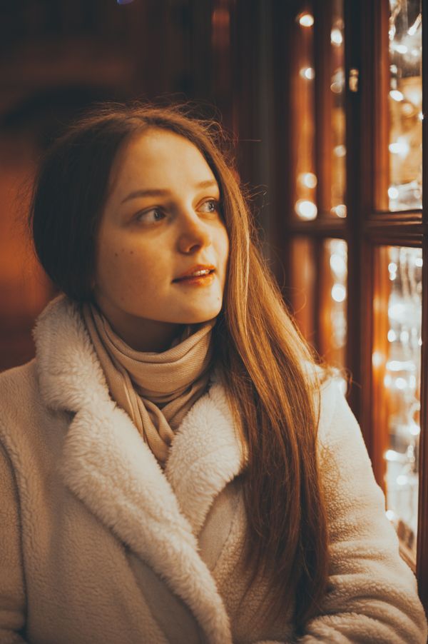 Woman in wool coat on Christmas lights street