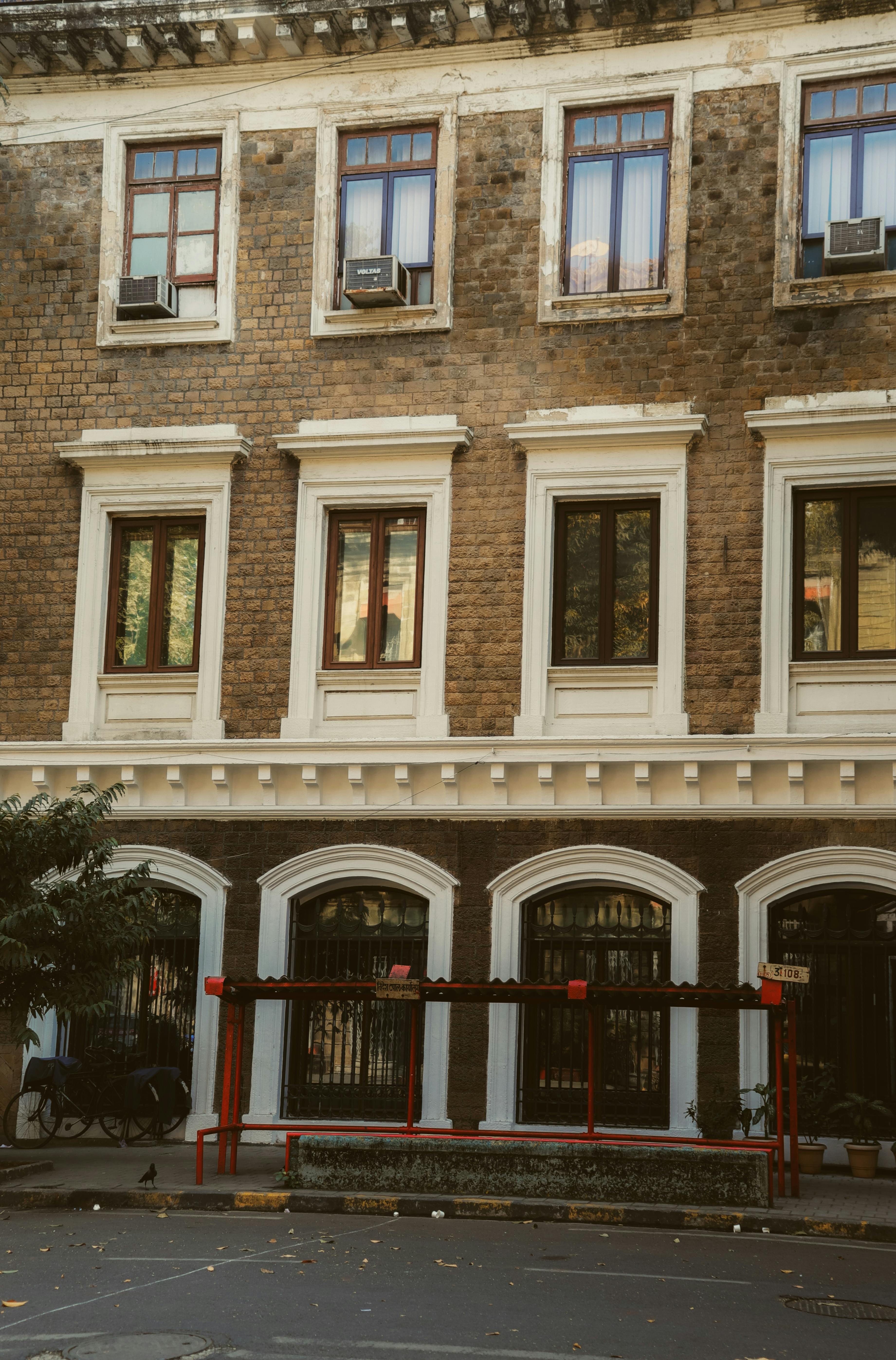 Elegant townhouse exterior featuring a brick facade and classic windows in an urban setting.