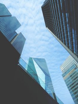 A stunning view of modern skyscrapers from below against a cloudy sky.