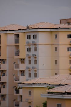 Colorful apartment buildings with balconies and satellite dishes in an urban setting.