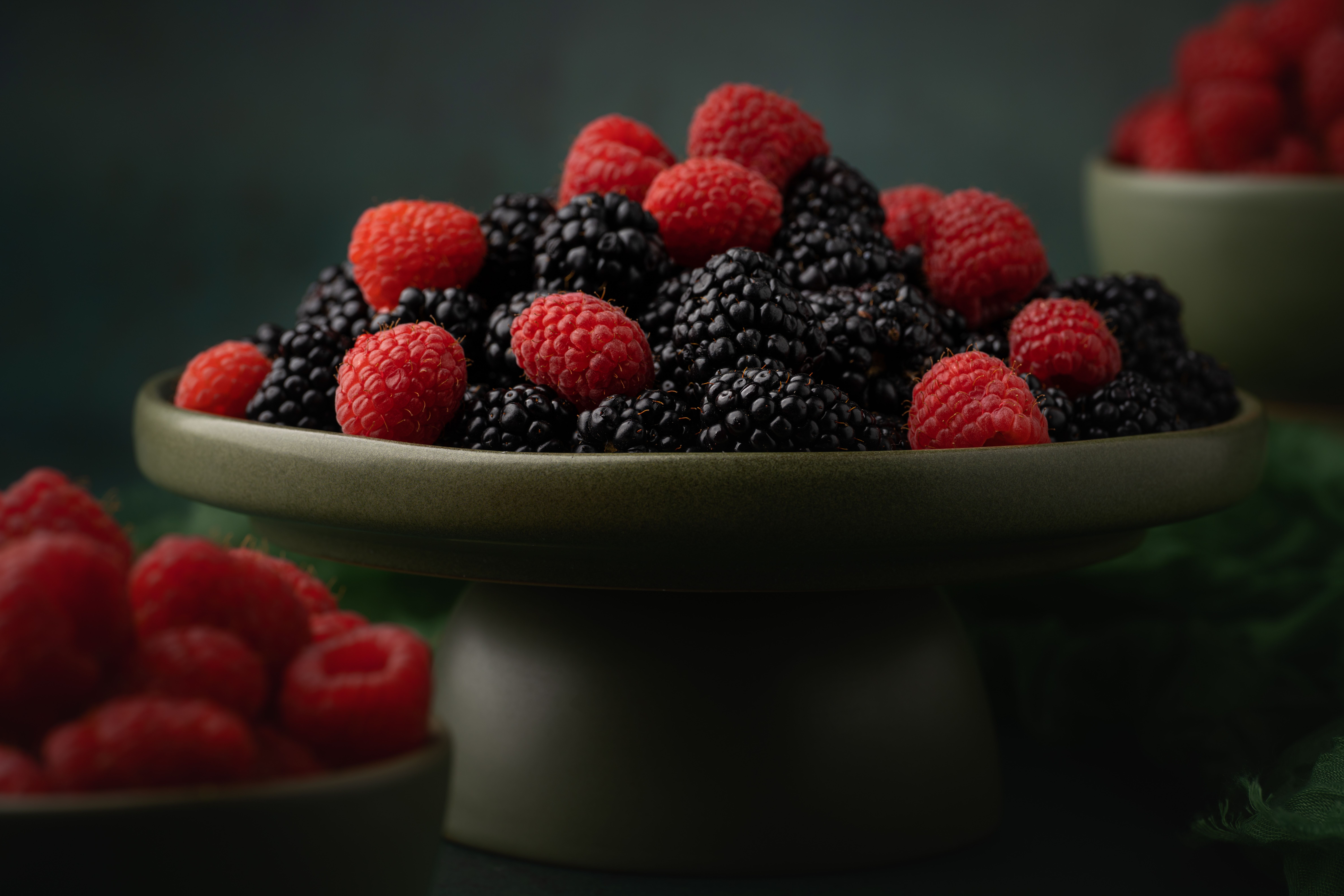 Tempting display of fresh raspberries and blackberries in a stylish bowl.