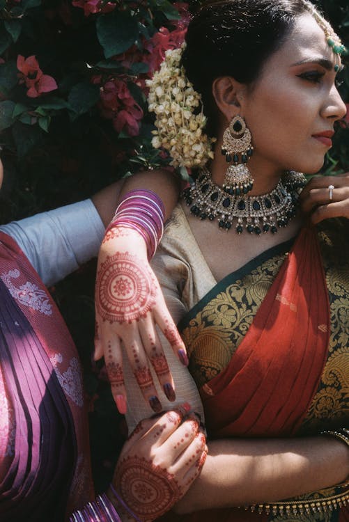 Indian Women Wearing Traditional Clothing and Jewelry and Standing Outside 
