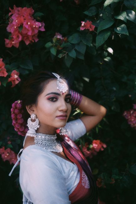A stunning portrait of a woman in traditional attire amidst vibrant flowers.
