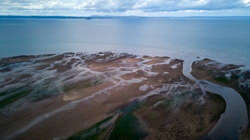 Aerial View of a Coast under a Cloudy Sky 
