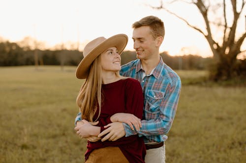 Free Man Embracing his Girlfriend from Behind while Smiling Stock Photo
