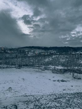 Captivating winter scene with snow-covered hills and a cloudy, moody sky.