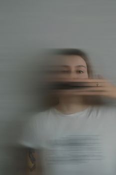 Artistic portrait featuring a blurred motion effect on a woman's face and hand.