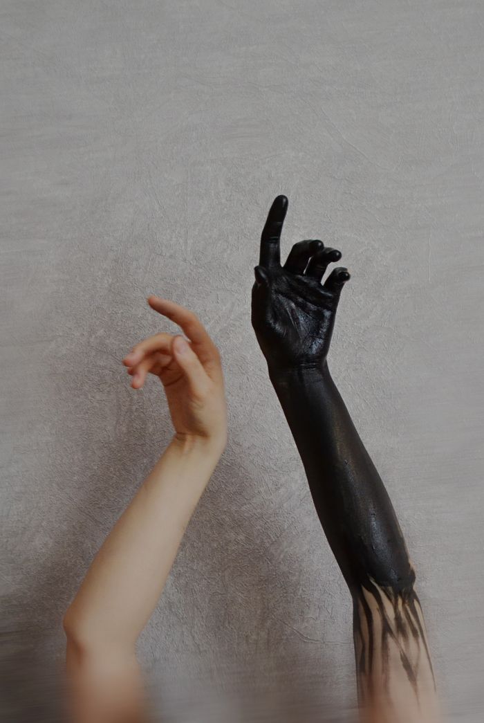 A natural hand alongside a painted arm reaching upward — photo by Darya Grey_Owl on Pexels