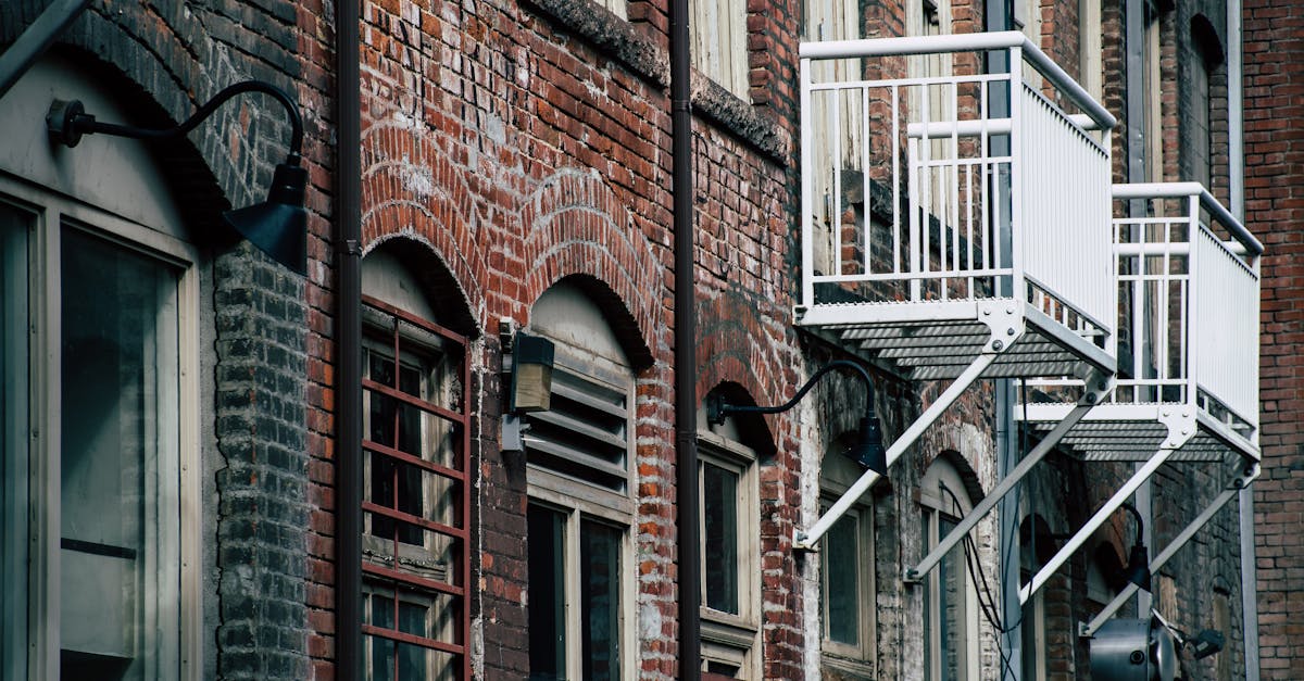 Detailed view of a historic brick building facade featuring industrial-style windows and metal balconies.