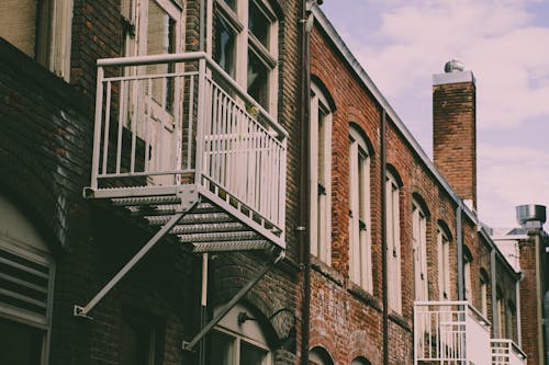 Closeup Photo of Brown Building With Fire Exit Ladder