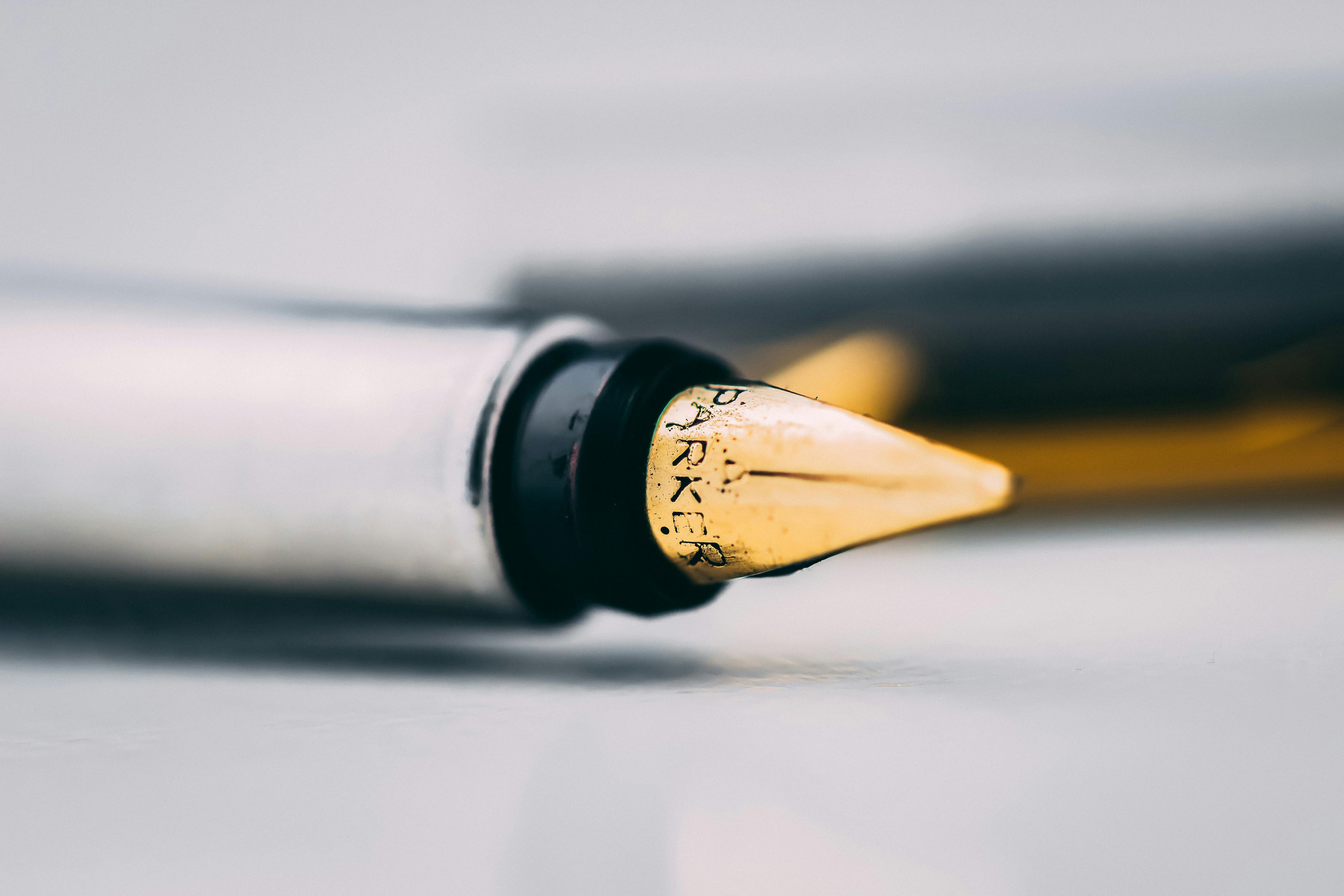 Selective Focus Photography of Fountain Pen on White Surface · Free