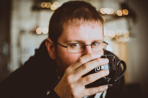 Man in Black Jacket Holding a Mug