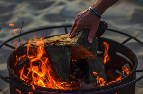 A Person Putting a Firewood in a Bonfire