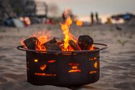 Man in Black Jacket Sitting on Black Metal Fire Pit