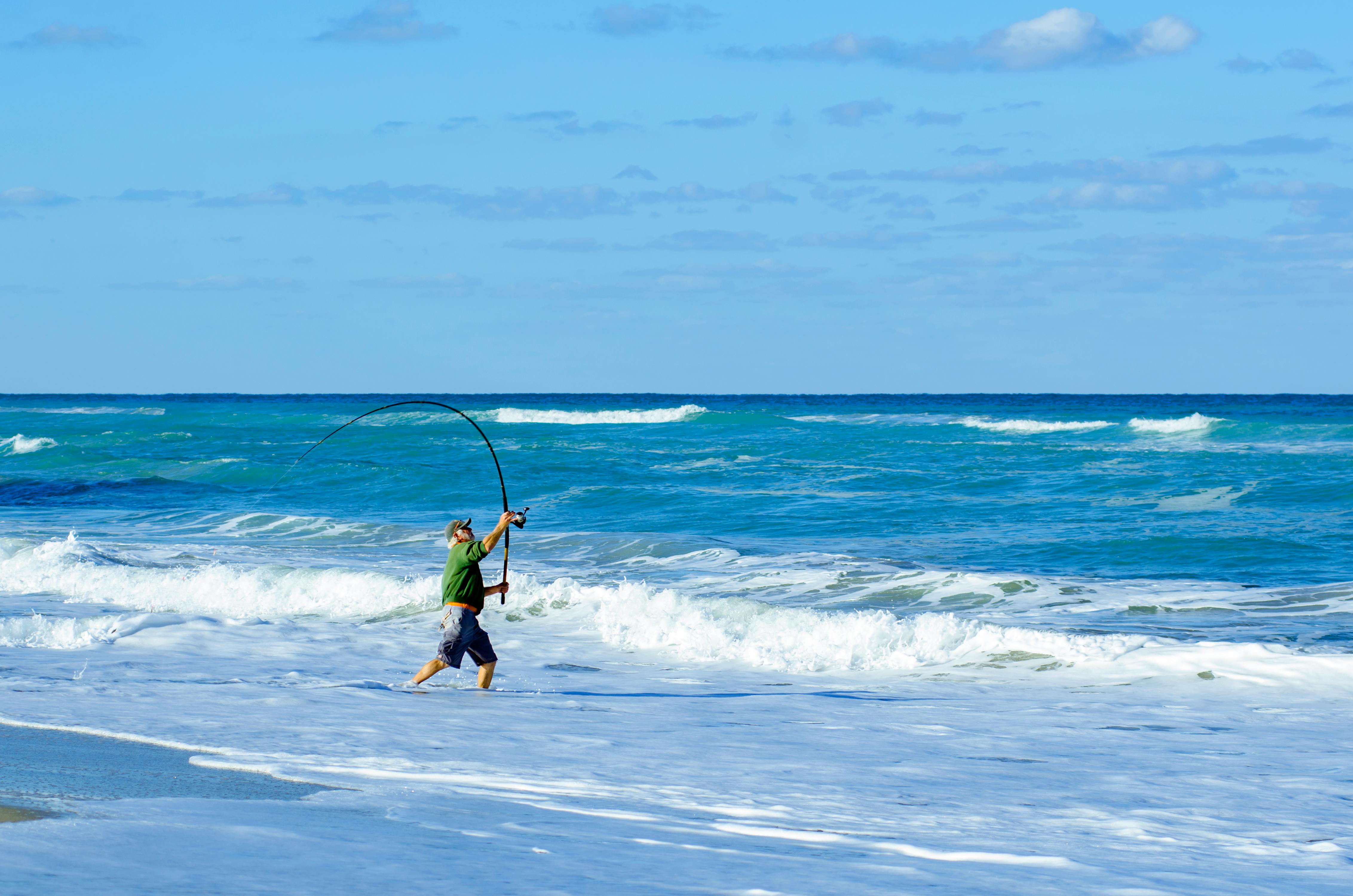 A man casting a fishing rod on a sunny day at West Palm Beach, Florida.