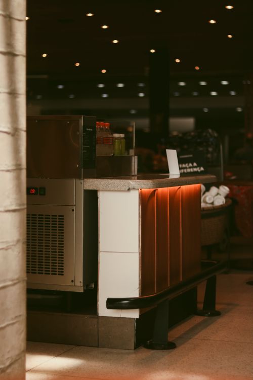 Free A cozy coffee counter in a dimly lit indoor setting with warm tones and ambient lighting. Stock Photo