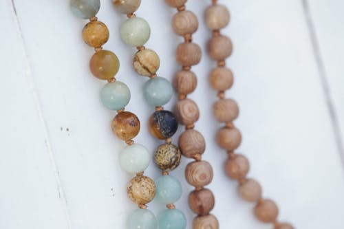 Free A String of Beads on a Wooden White Wall Stock Photo