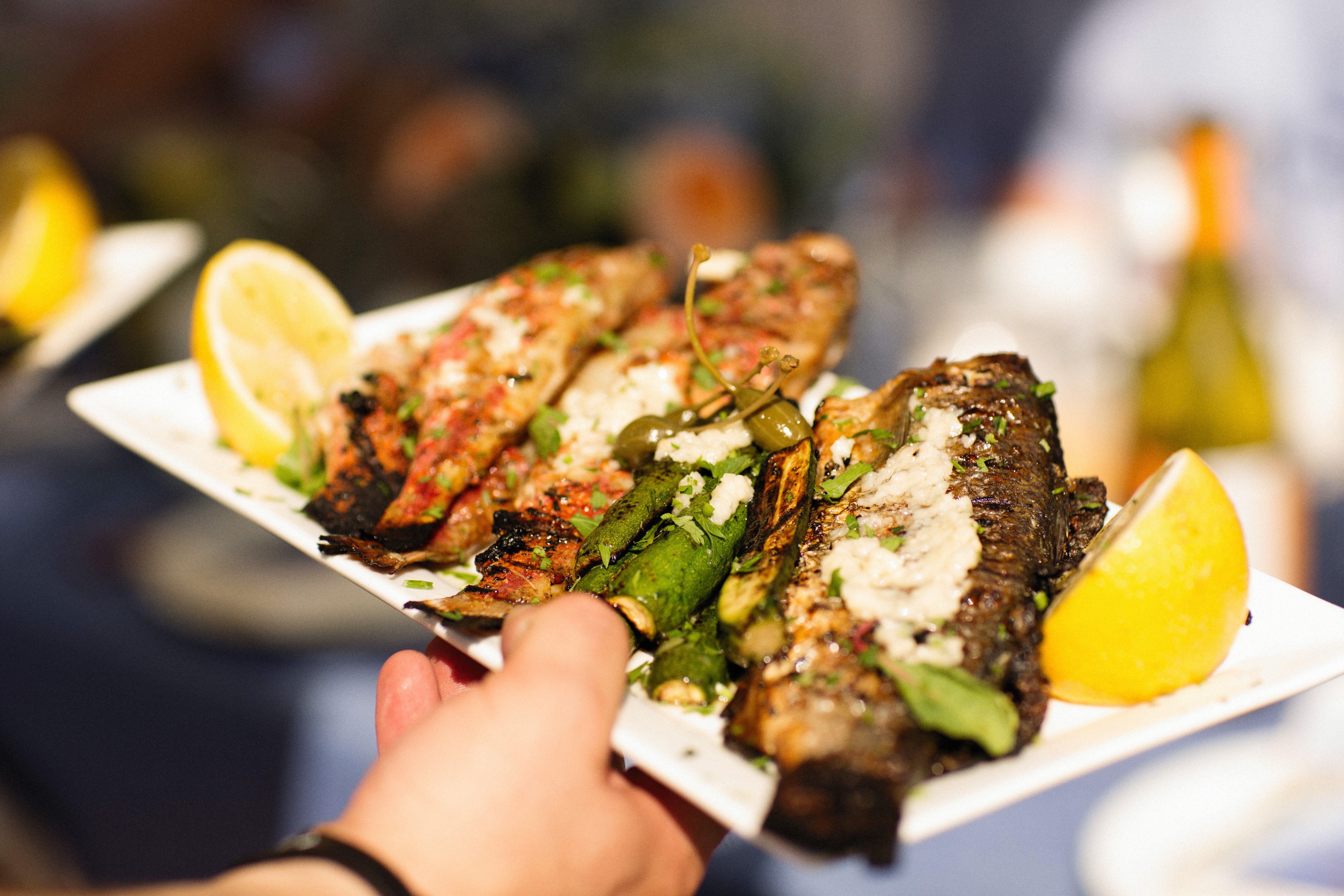 Whole grilled fish dressed in herbs and lemon