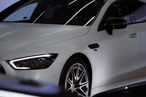 Free Close-up shot of a luxury white Mercedes Benz car in a showroom showcasing the sleek front design. Stock Photo