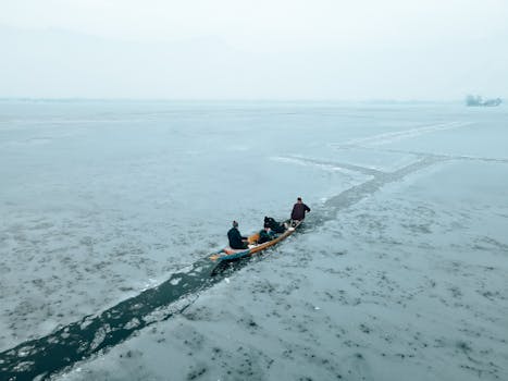 A group of people kayaking through icy waters on a frozen lake during winter.