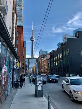 Dynamic street scene in downtown Toronto featuring the iconic CN Tower and bustling city life.