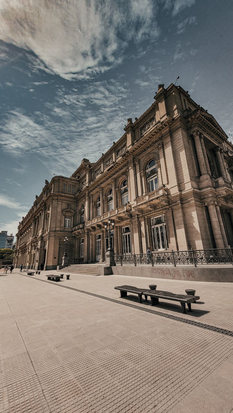 Fachada del Teatro Colón en Buenos Aires bajo cielo dramático