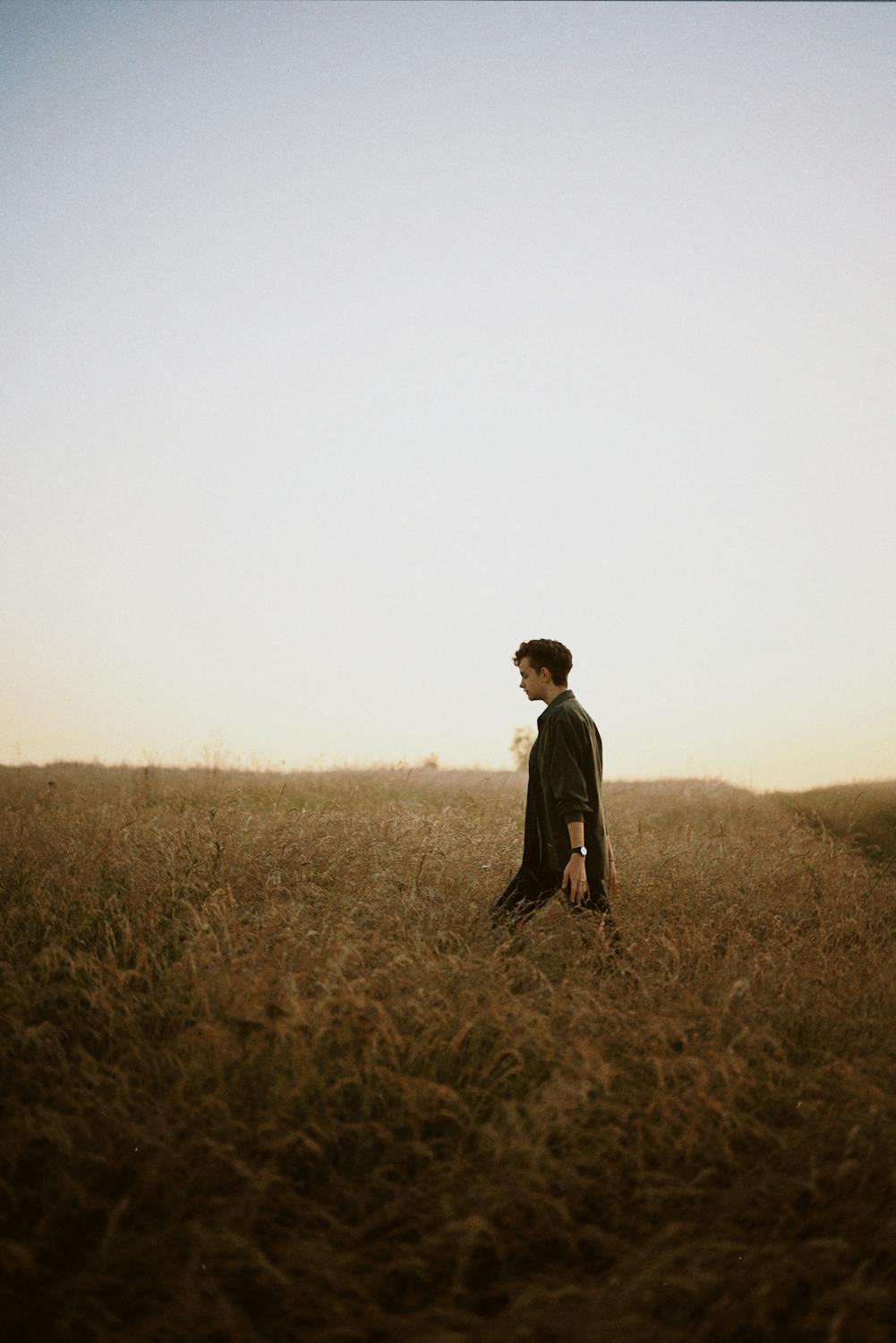 A Man in Black Long Sleeve Standing on Brown Grass Field · Free Stock Photo