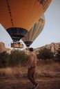 Man in Hat Approaching Balloons Landing on Prairie