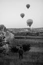 Unrecognizable Man Observing Balloon Competition Over Prairie