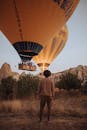 Two Balloons Landing on Prairie and Man Watching Them